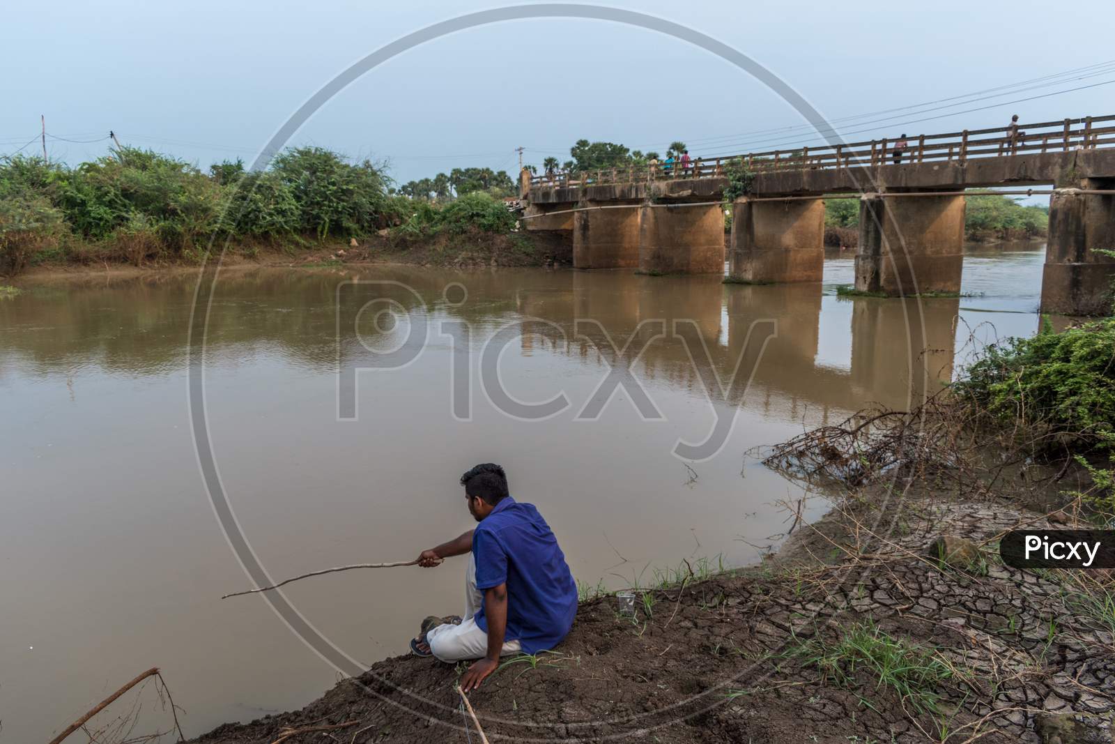 a man is fishing on the bank of river