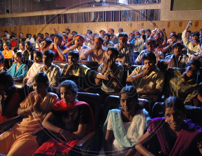 Crowd Cheering With Papers In a  Movie Theater Enjoying a Movie Release