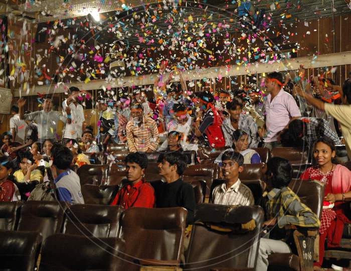 Crowd Cheering With Papers In a  Movie Theater Enjoying a Movie Release