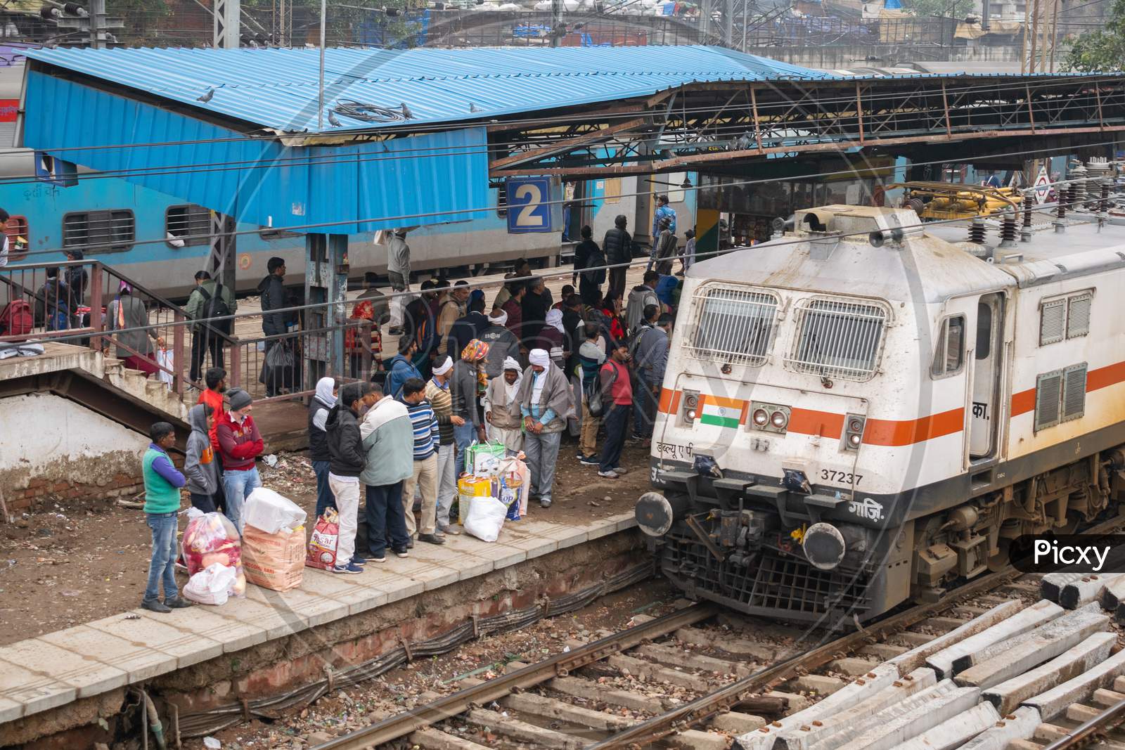 passengers waiting for the train and a train arriving at the platform at Delhi Sadar Bazar railway station