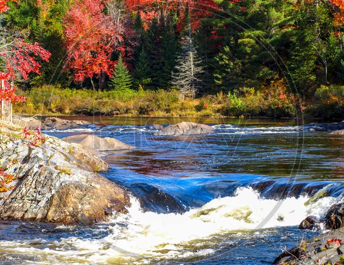 Mix of sky, clouds, river, fall foliage and rocks, Chutes Prov Park, ON, Canada