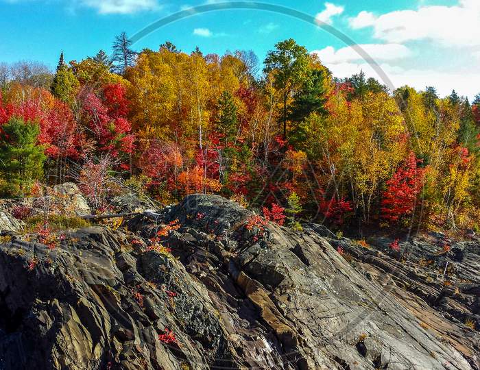 Large brown boulders define the fall foliage, Chutes Prov Park, ON, Canada