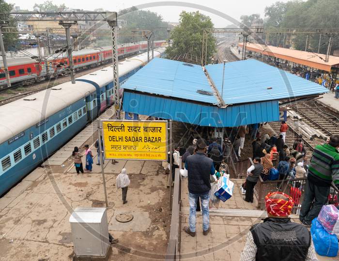 passengers waiting at the platforms and trains passing through delhi sadar bazar railway station