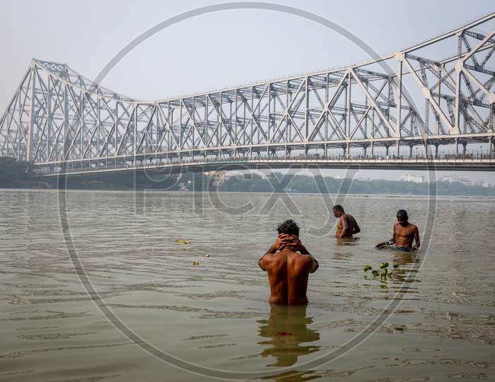 A View Of Howrah Bridge With People Taking Bath in Hooghly River  in Kolkata