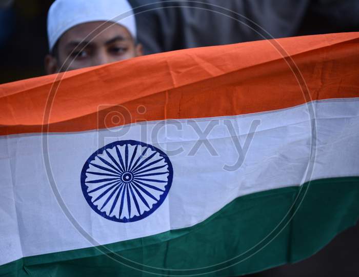 A muslim protester holds Indian Flag while demonstrating against CAA 2019 Act