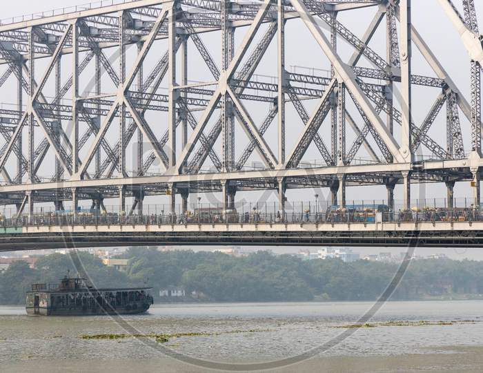 A View Of Howrah Bridge Over Hooghly River and Commuting Boats in Kolkata