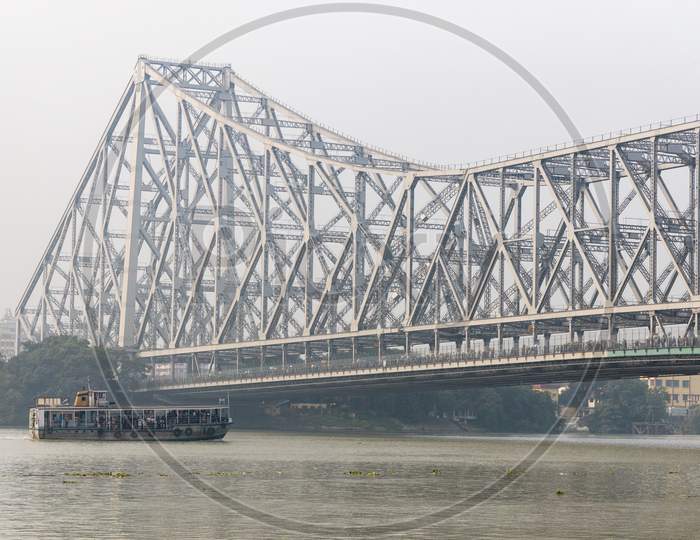 A View Of Howrah Bridge Over Hooghly River and Commuting Boats in Kolkata