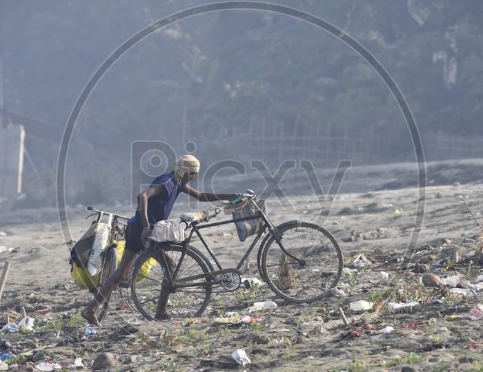 A Fisherman  With Bicycle on Bramhaputra River Bank