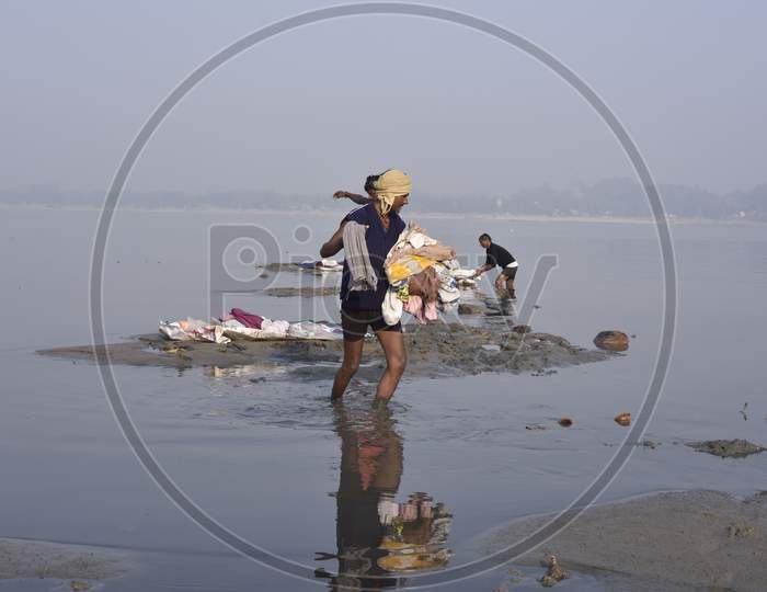 Indian Washer Man Or Dhobi  Washing Clothes in River Bramhaputra In Assam