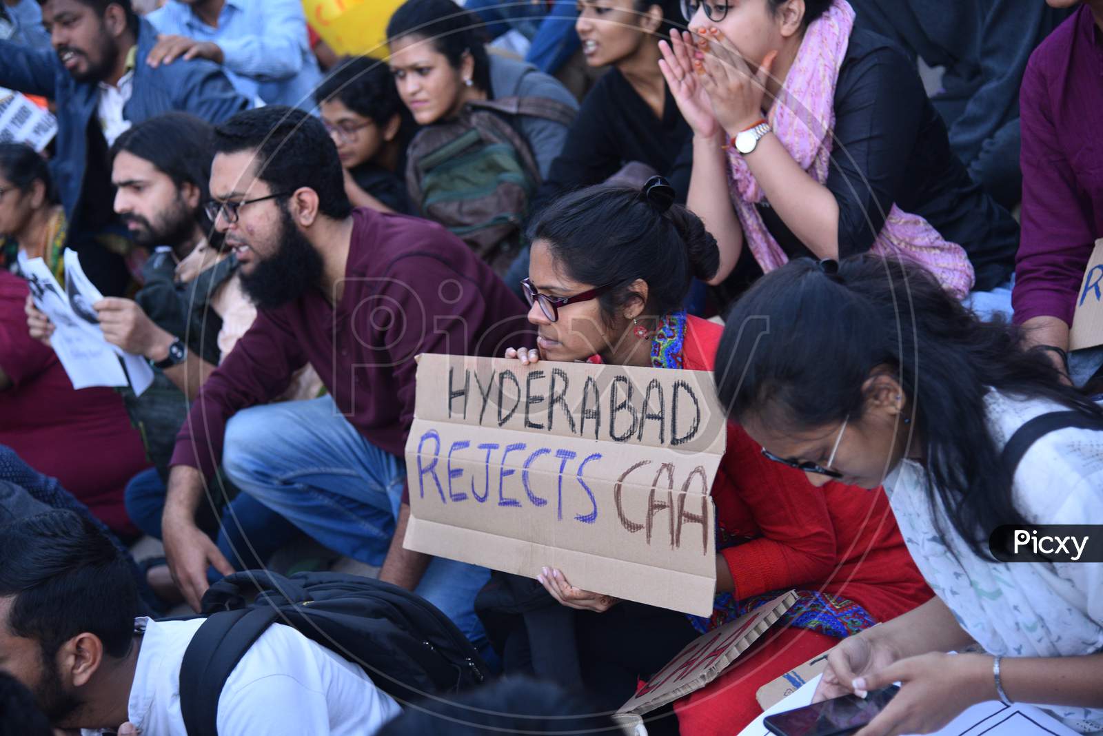 A woman protester holds a placard with 'Hyderabad rejects CAA' slogan written