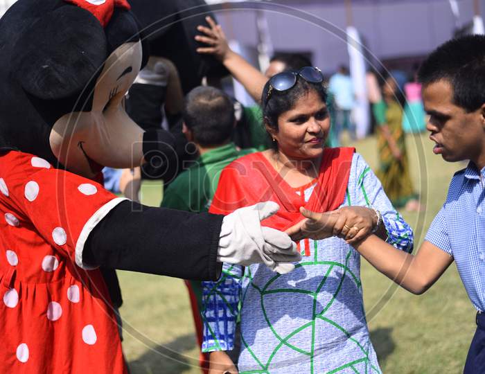 A mickey mouse dressed clown plays with Intellectually challenged kid