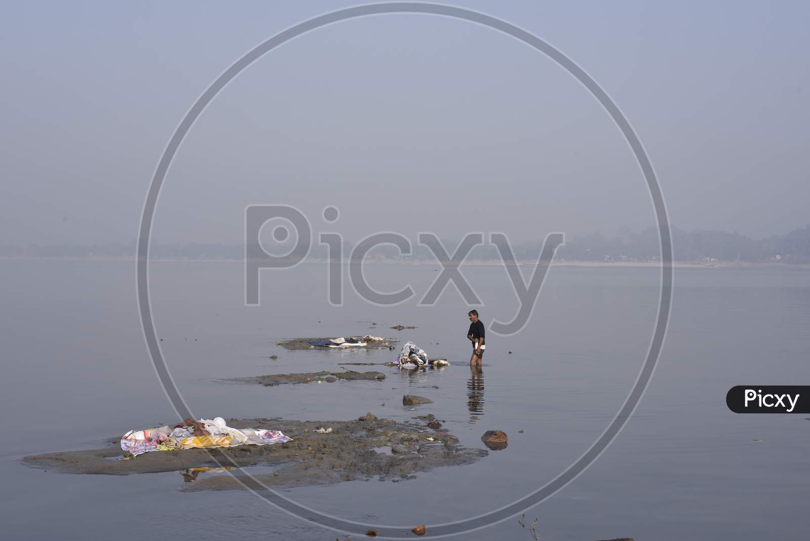 A Washer Man Or Dhobi  Washing Clothes on River in Assam