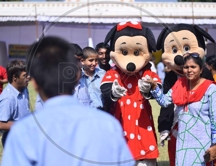 A mickey mouse dressed clown plays with Intellectually challenged kids