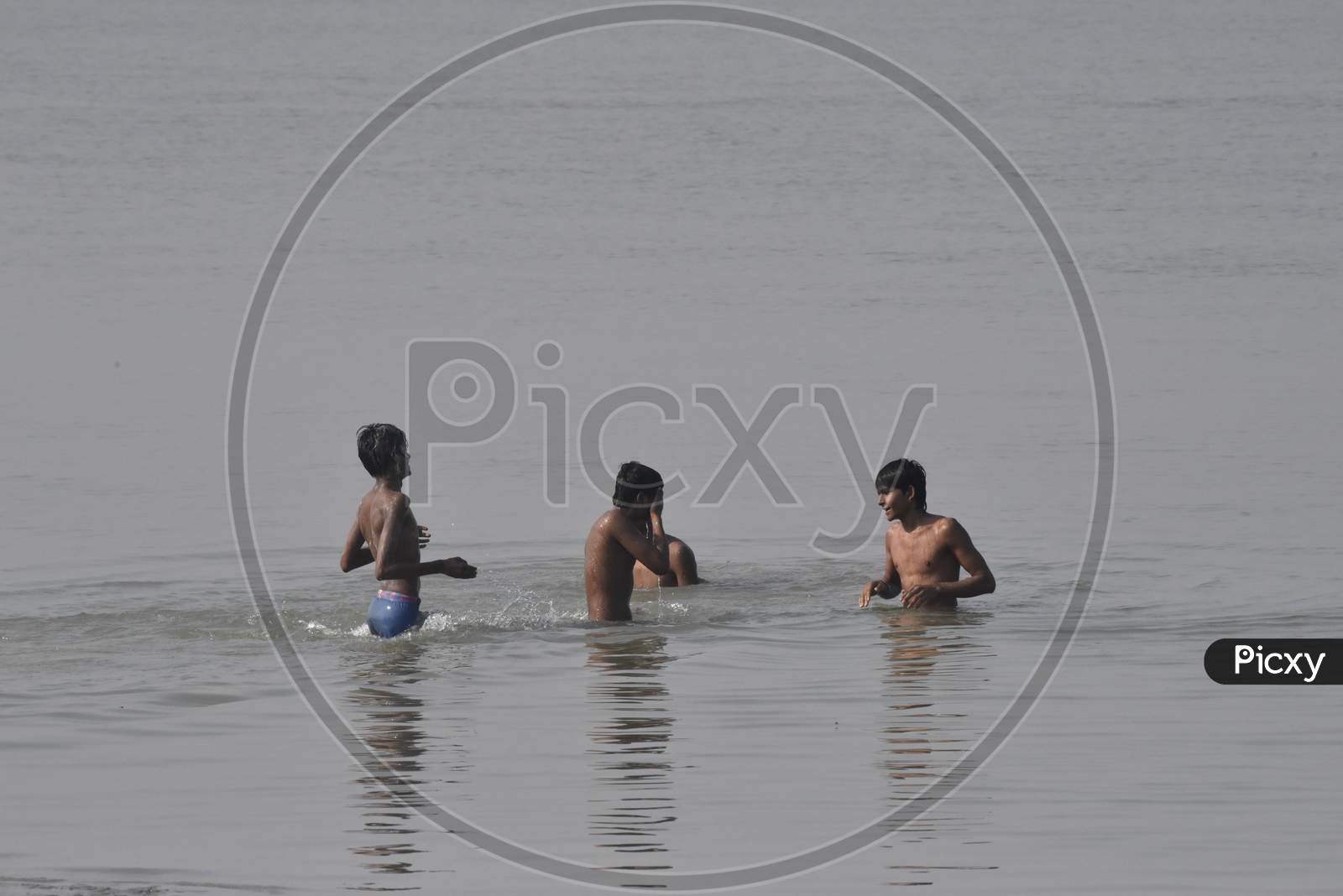 Young Indian Boys  Swimming In River Bramaputra In Assam