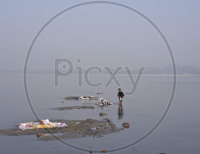 A Washer Man Or Dhobi  Washing Clothes on River in Assam