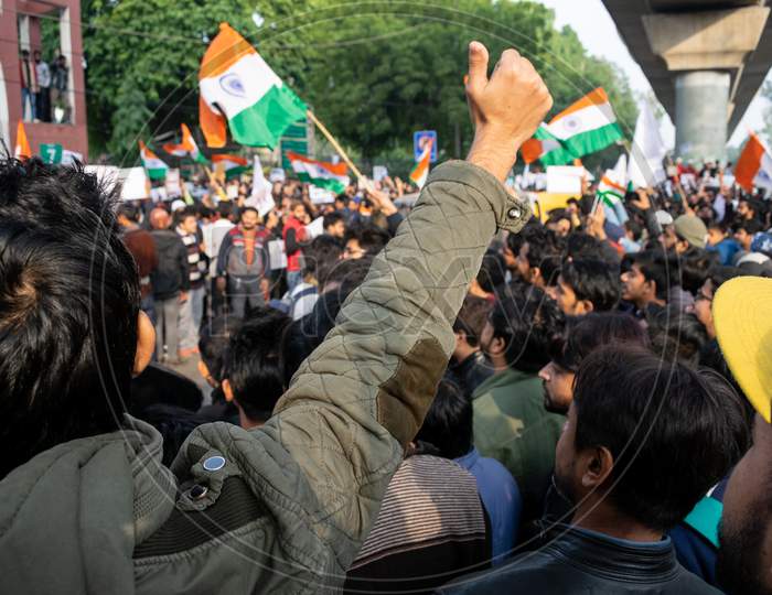 A student with raising hand and People With Indian Flags banners and posters Protesting Against Caa And Nrc Outside Bab E Maulana Abul Kalam Azad Gate No 7 Jamia Millia Islamia A Central University In New Delhi