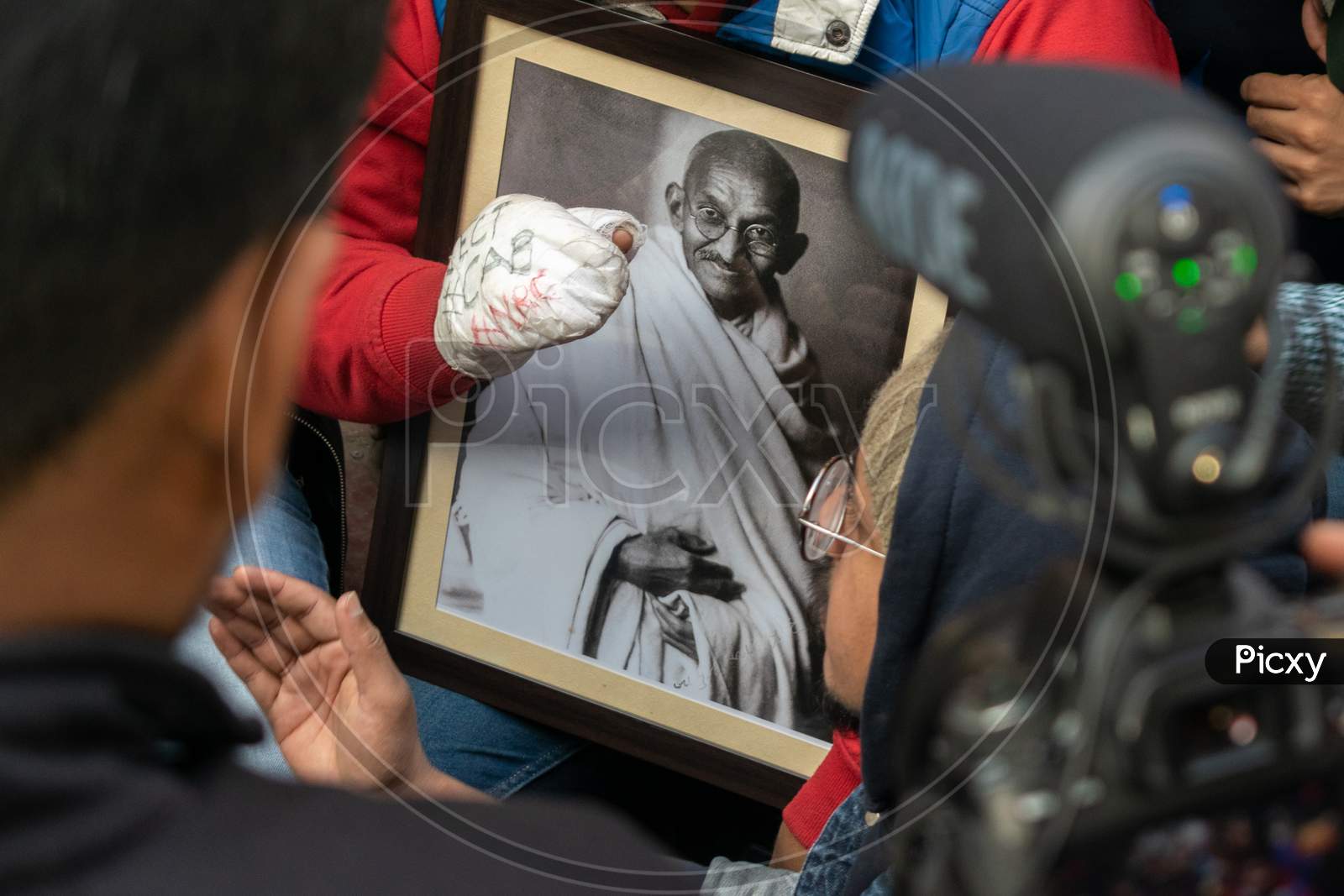A Student holding picture of Mahatma Gandhi during protest against CAA and NRC outside Jamia Millia Islamia, A Central University in New Delhi