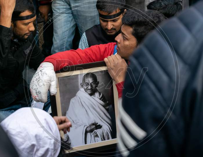 Students holding a picture of Mahatma Gandhi during protest against CAA and NRC outside Jamia Millia Islamia, A Central University in New Delhi