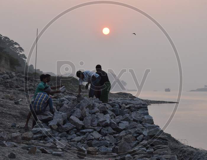 Fisherman Setting Up Rocks on The Bank Of Bramaputra River in Assam