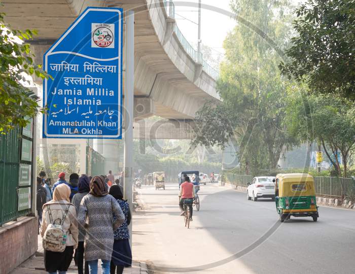 Sign board for Jamia Millia Islamia Central University and Delhi Metro line passing over it