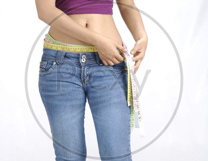 Indian girl measuring her waist using a tape