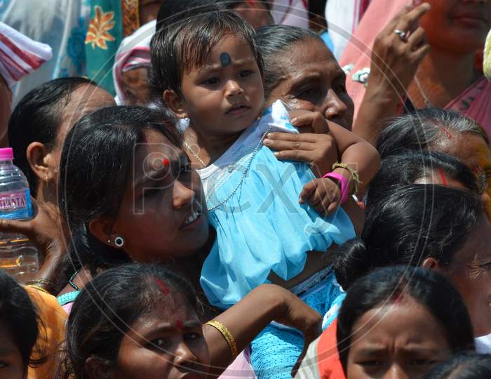 A Mother Carrying Her Girl Child Over Shoulders During Election Campaign Meeting