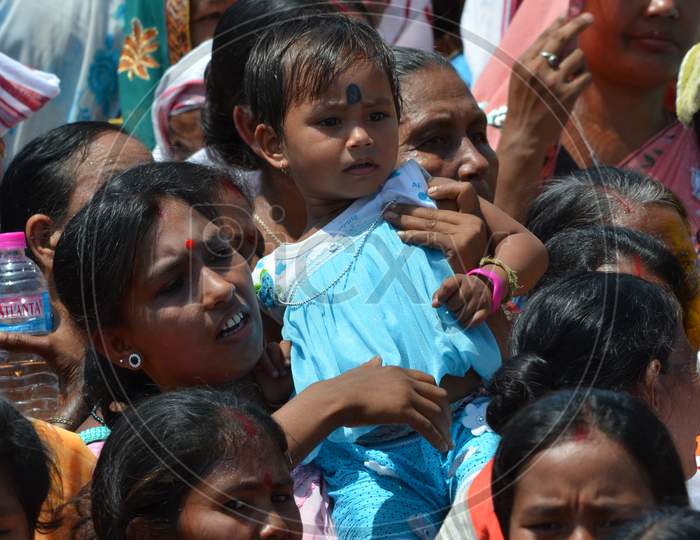 A Mother Carrying Her Girl Child Over Shoulders During Election Campaign Meeting