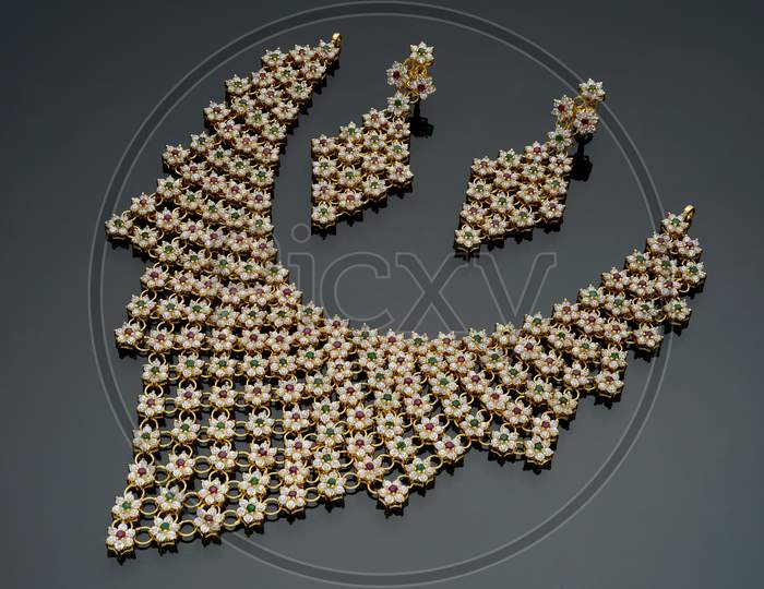 Indian Fancy small gemstone embedded necklace piece on a black background