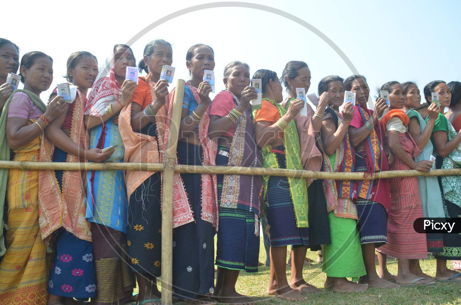 Indian Voters  Showing Voter ID Cards by Standing In Queue Lines For Casting Vote in Assam Assembly Elections 2016