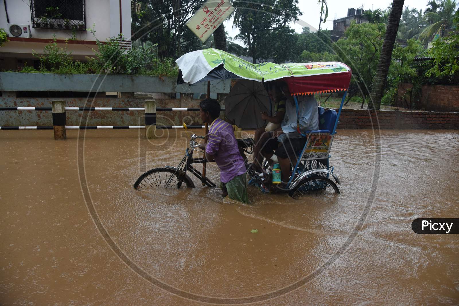A Rickshaw Riding   on Flooded Roads Of Guwahati Due To Seasonal Floods in Guwahati City , Assam