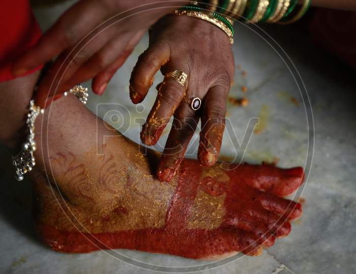 Indian Bride applying turmeric to her legs