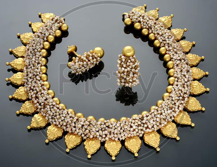 Woman's gold coated necklace set with matching earrings