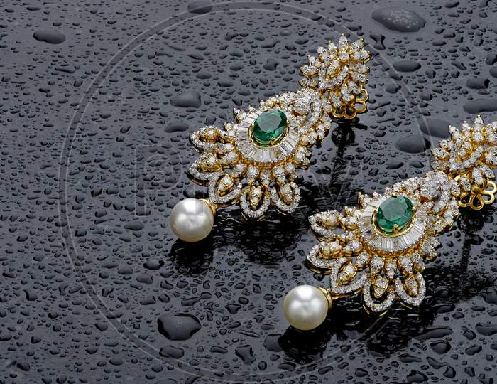 Green gemstone earrings set with water droplets