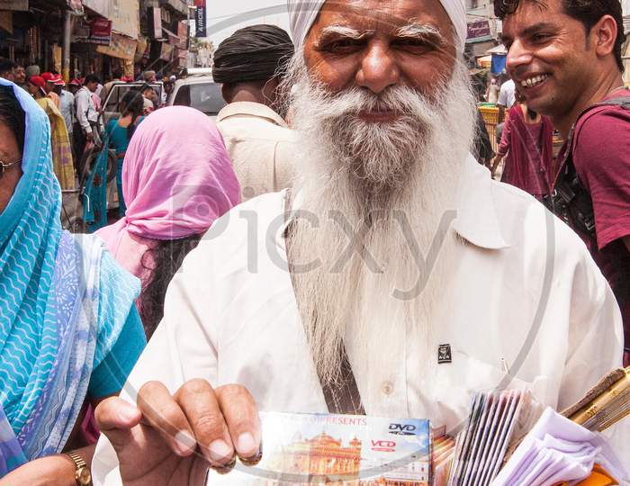 Old man selling DVD of Jallianwala Bagh massacre, Amritsar