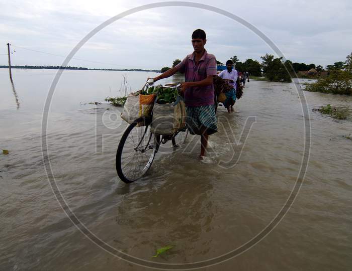Vendors Crosses Flood Waters In The Flood Affected Morigaon District Of Assam On July 22,2016