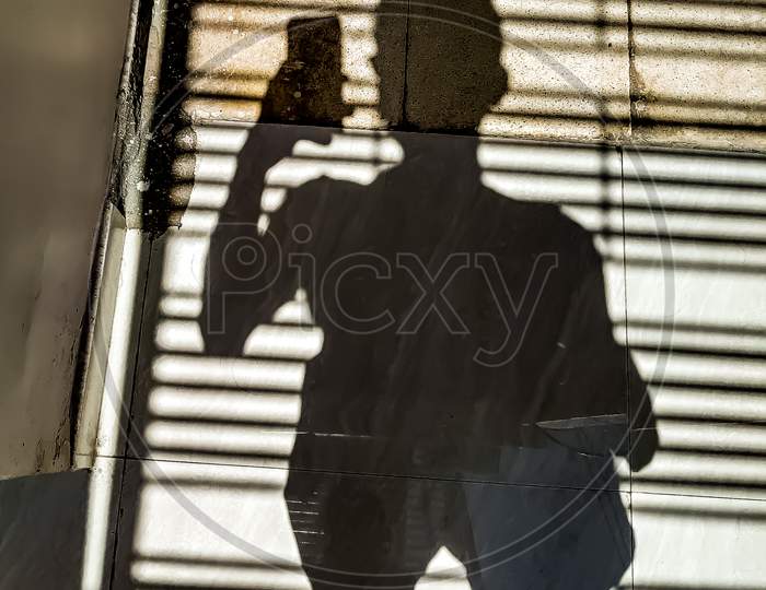 Shadow of a Man Taking a Picture With Smartphone