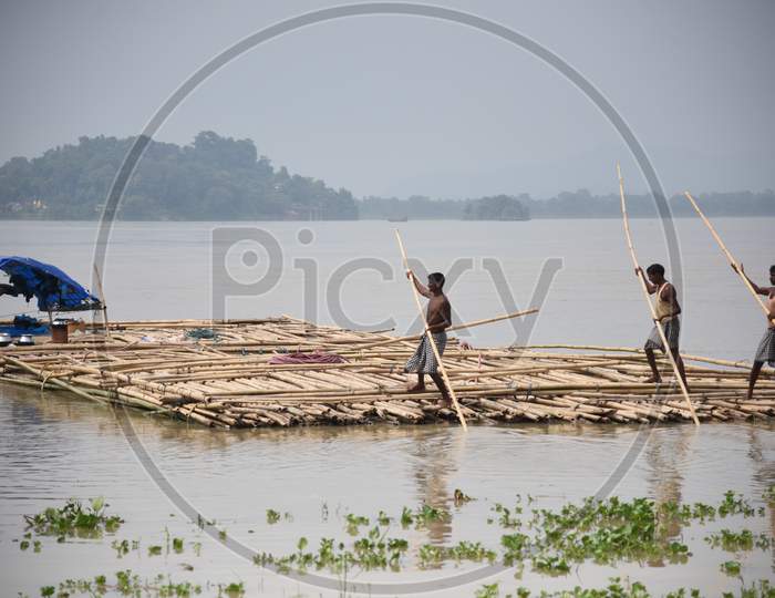 Laborers busy working at a wholesale Bamboo market alongside the banks of river Brahmaputra, in Guwahati on 11th September 2017
