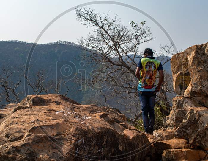 A Man Standing on Rocks