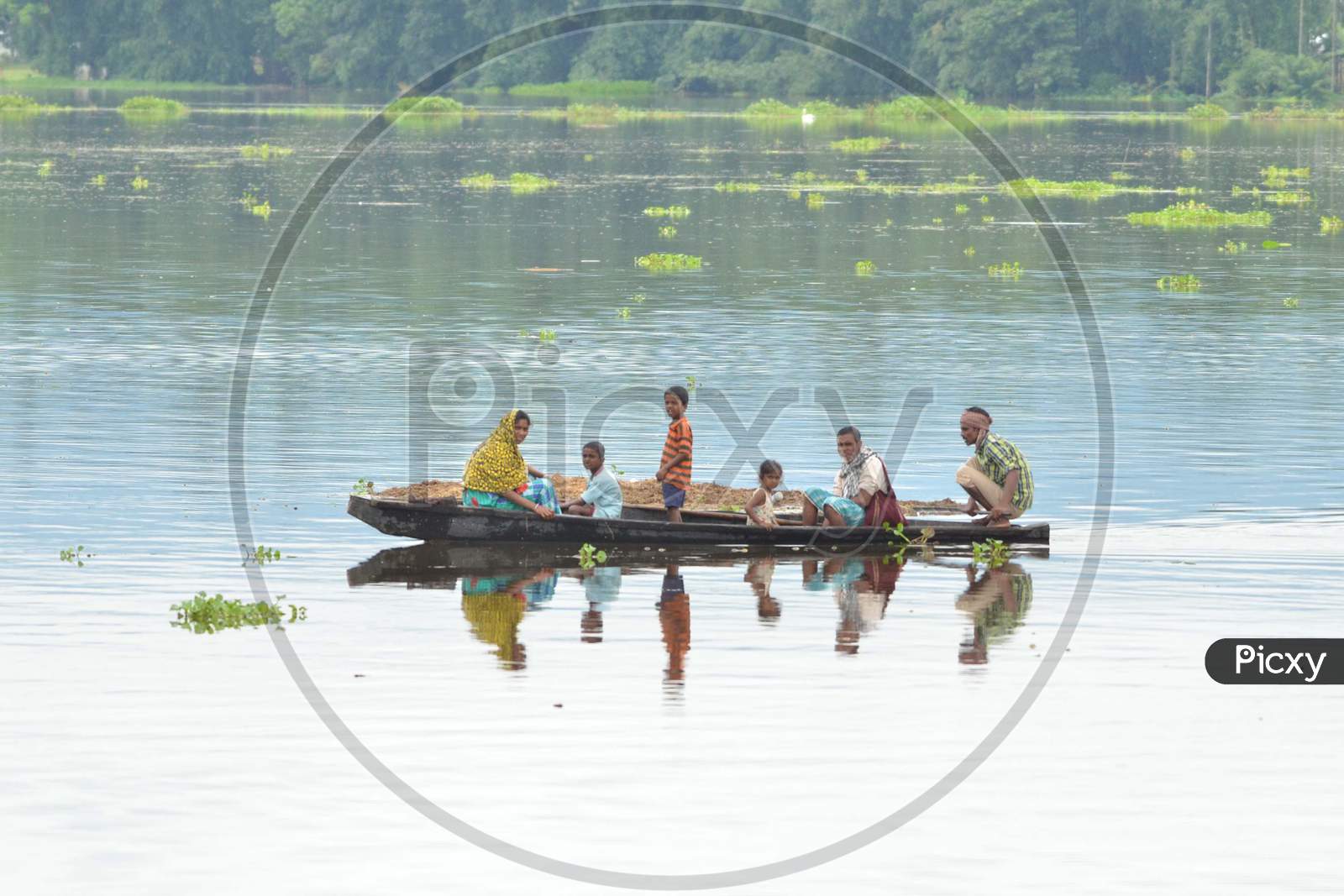 Villagers Uses A bamboo Raft T Near Submerged Houses In A Village Near Kaziranga National Park In Golaghat District Of Assam On July 26,2016