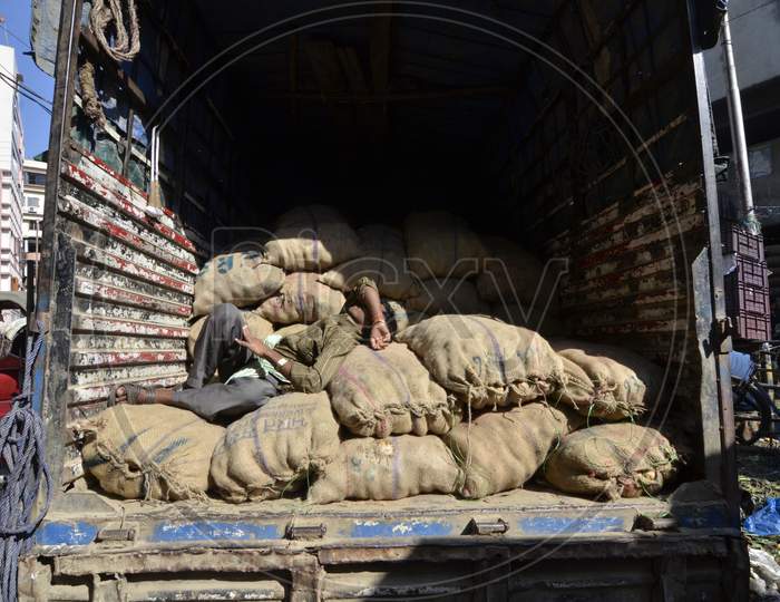 Daily Labor Worker Resting on Goods Bags  on a Transport Vehicle In Guwahati Fancy Bazaar , Assam