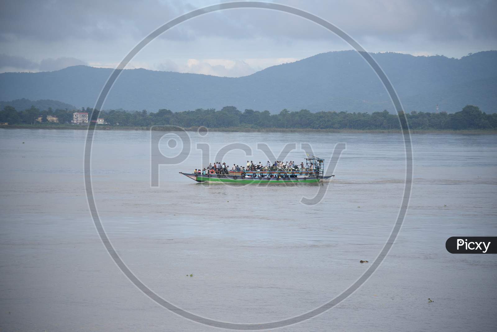 People from India's northeastern states travel on a boat through the waters of river Brahmaputra, back to their homes at Nimati Ghat, August 21, 2012