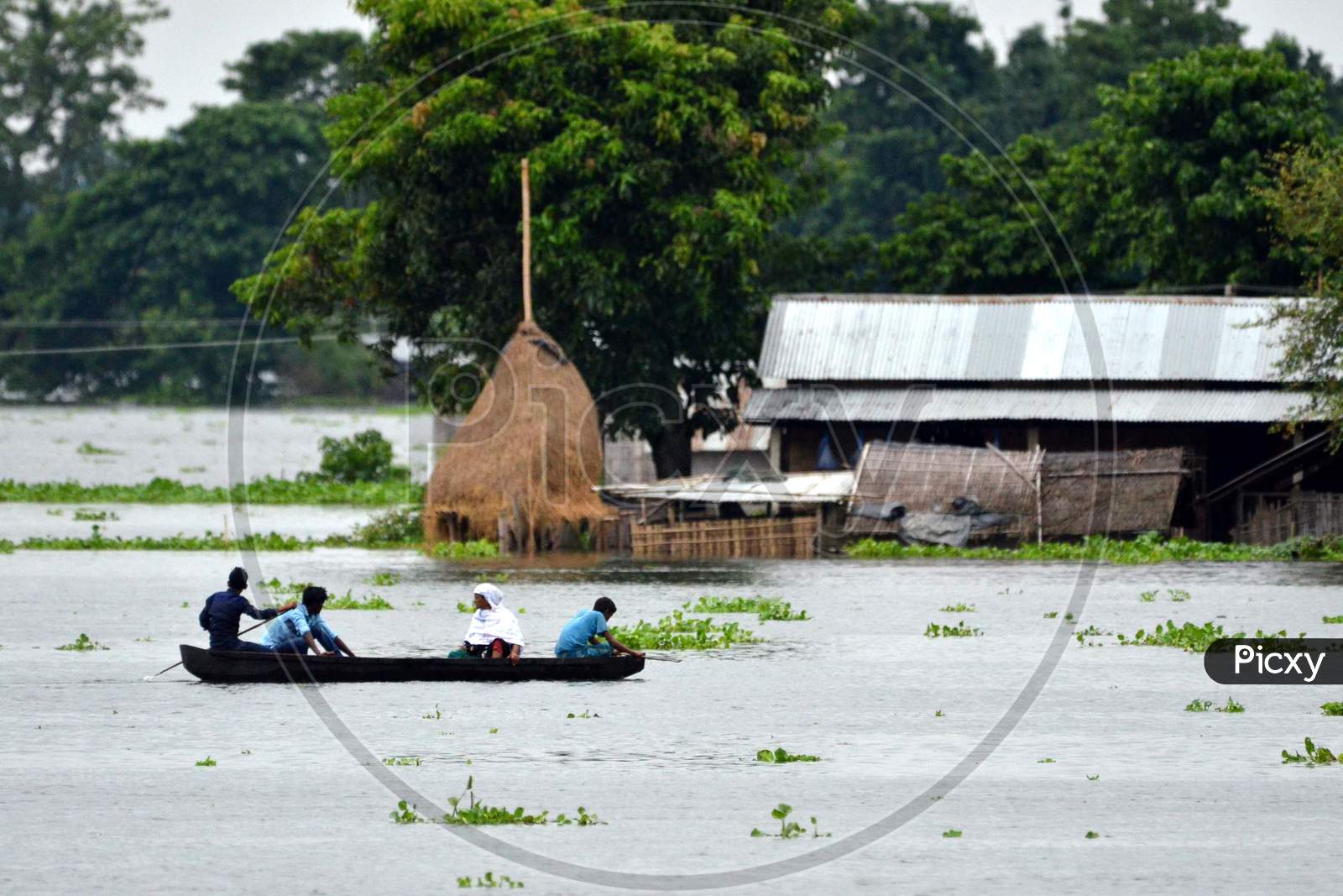 Villagers Uses A bamboo Raft T Near Submerged Houses In A Village Near Kaziranga National Park In Golaghat District Of Assam On July 26,2016