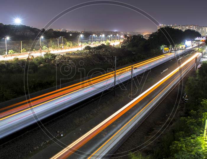 Long Exposure Of Moving Vehicles And MMTS Trains  At a Local Railway Station