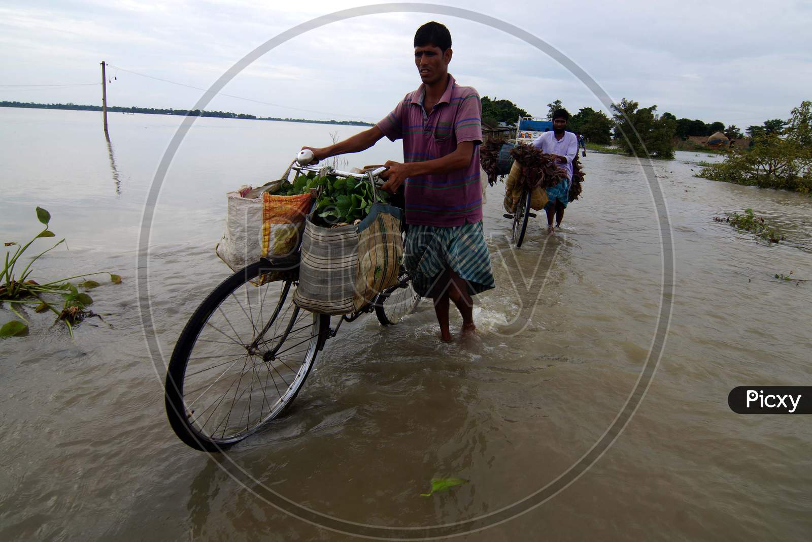 Villagers Crosses Flood Waters In The Flood Affected Morigaon District Of Assam On July 22,2016
