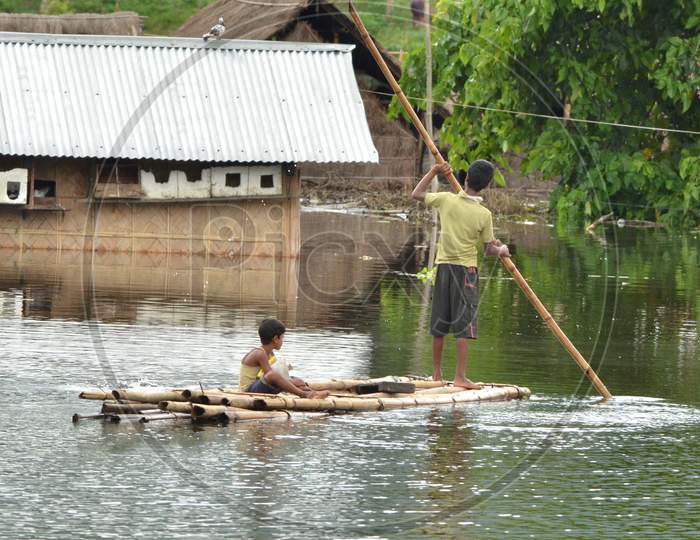 Villagers Uses Abamboo Raft T Near Submerged Houses In A Village Near Kaziranga National Park In Golaghat District Of Assam On July 26,2016