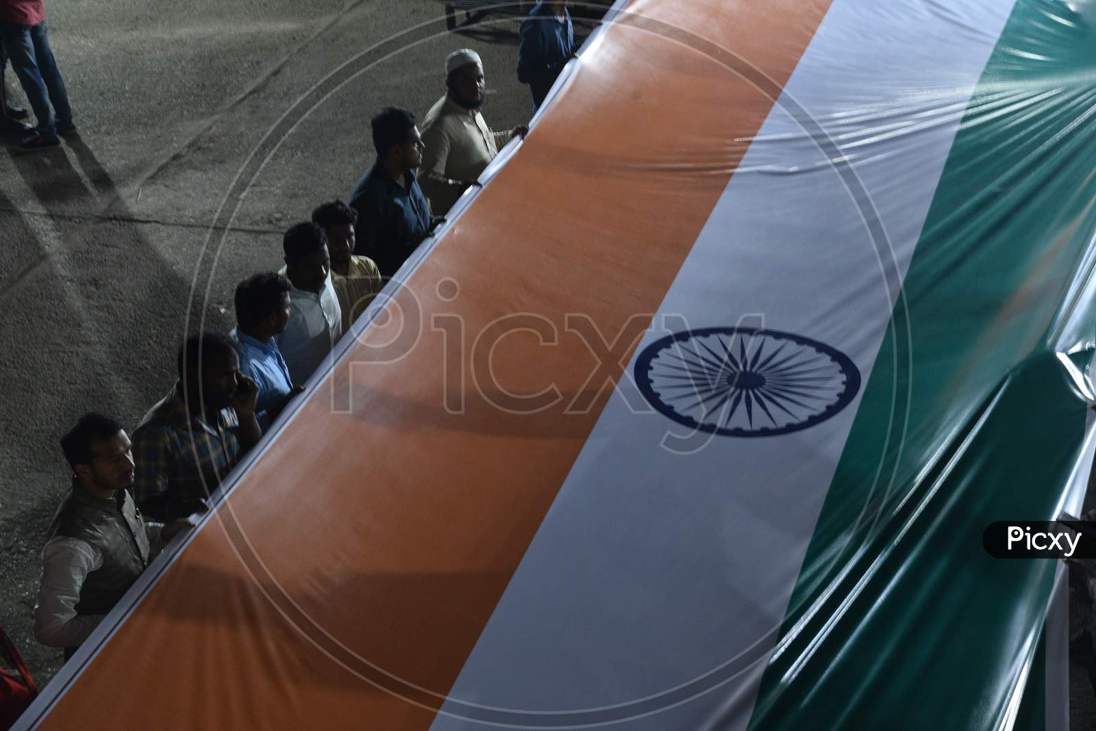 men hold Indian National Flag  at a protest against CAA and NRC at Osmania Arts College