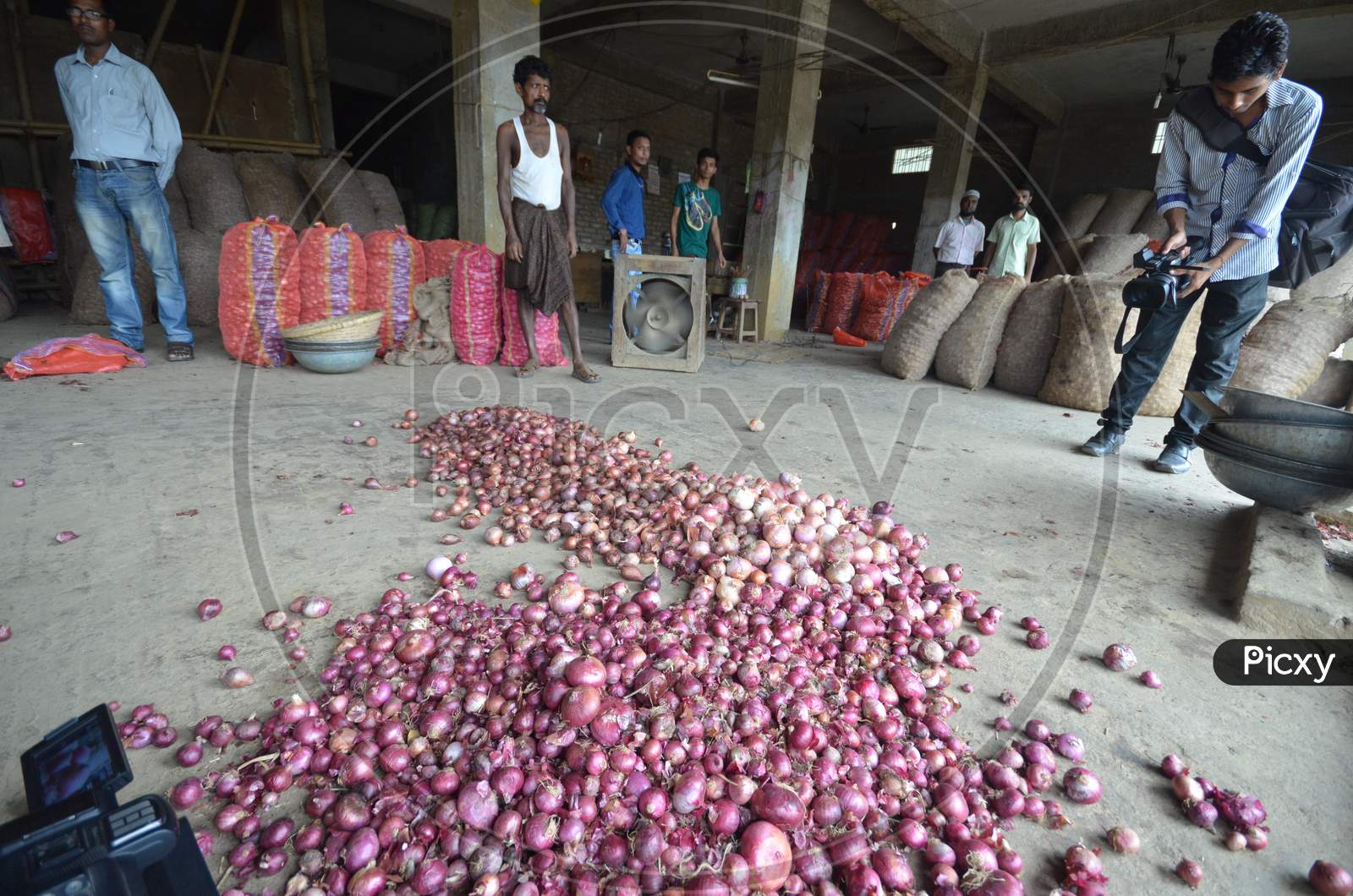 Indian Laborers Unloading Onion   Sacks At  A   Wholesale Market In Nagaon Some Of 180Km East Of Guwahati , India July 14, 2014