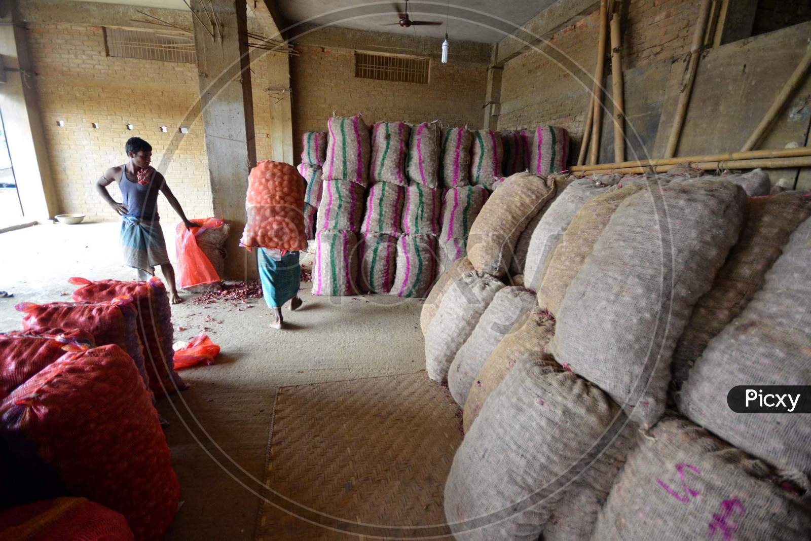 Indian Laborers Unloading Potato  Sacks At  At A   Wholesale Market In Nagaon Some Of 180Km East Of Guwahati , India July 14, 2014
