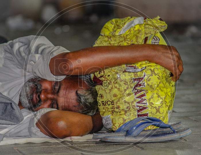 A Man Sleeping By Holding His Bag