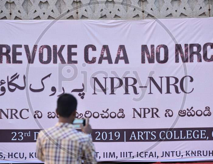 A man takes photo of the poster against NRC and CAA at Osmania University